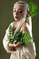 Naklejka premium Beautiful elf girl with floral decor on dark olive background