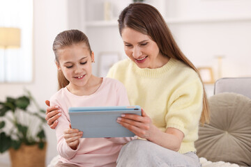 Fototapeta premium Mother and her daughter using tablet at home