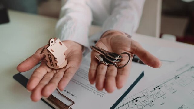 Moment of receiving house keys from female agent over signed papers. Symbol of new apartment ownership, moving day, successful purchase and comfortable future home lifestyle ahead.