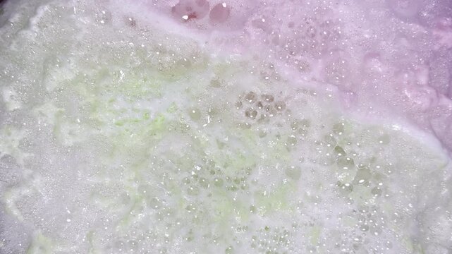 Colorful bath bomb foam expands and bubbles up