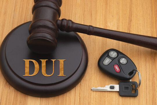 DUI message with judge gavel and block on wood desk with car keys
