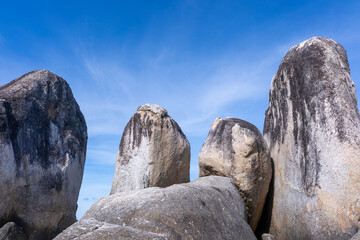 Distinctive upright granite formations known rising from white sandy beach under clear blue sky © LaTerase