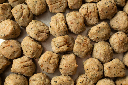 A top down view of a layer of chicken meatballs, as a background.