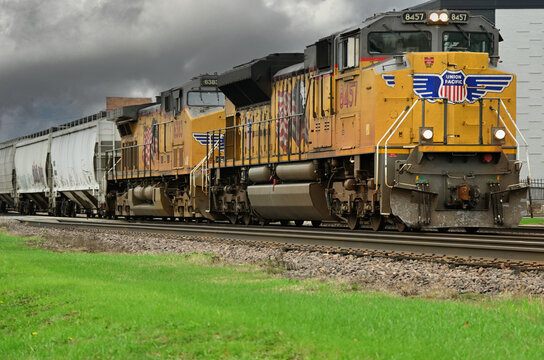 Multiple locomotives lead a Union Pacific Railroad freight train through a suburban Chicago community on its eastbound journey toward the city.