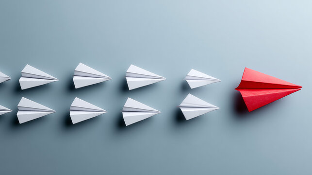 Leading the Pack: A dynamic paper airplane takes flight, spearheading a formation of its white counterparts.