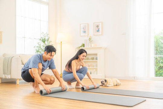Asian couple practicing yoga class exercise at home, healthy wellness lifestyle fitness routine, stretching and balance poses, indoor workout for flexibility strength, relaxation mindfulness training