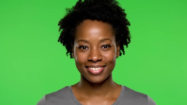A young Black woman smiling confidently at the camera, captured in a medium shot against a vibrant green background, perfect for diverse lifestyle and professional applications