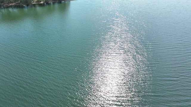 Aerial lake island sun flare Poland 1. Northern Poland. Spring summer season, Trails and lake. Recreation for fishing, picnic, swimming, boating and hiking. forests with farm agriculture.