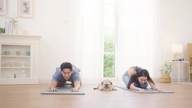 Asian couple practicing yoga class exercise at home, healthy wellness lifestyle fitness routine, stretching and balance poses, indoor workout for flexibility strength, relaxation mindfulness training