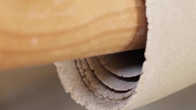 A macro view showing multiple layers of thick, textured fresh dough. The footage captures the detailed grain and soft edges of the raw dough as it is being processed or rolled, highlighting its organi