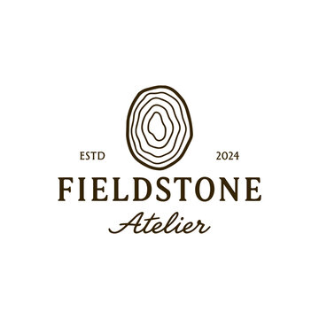 Fieldstone atelier logo with a tree ring design suitable for naturebased businesses or environmental organizations. Rustic charm meets modern branding.