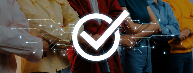 A diverse group of individuals stands with arms crossed, symbolizing confidence and unity, with a digital check mark overlay, showcasing collaboration in a professional environment. Trope © InfiniteFlow