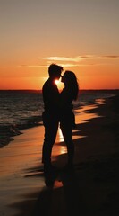 Fototapeta premium Couple embraces on beach sand during sunset. Orange sky reflects on ocean waves. Warm evening highlights romantic love, close relationship, and vacation joy.