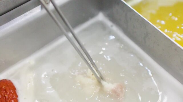 Close Up of Chopsticks Cooking Meat in Boiling Shabu Shabu Broth