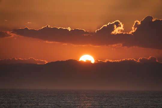 【南知多】海上の雲の間に沈むオレンジ色の夕日