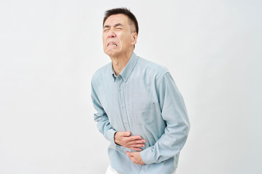 白背景で腹痛の男性