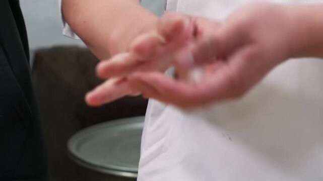 A close-up shot of a chef or artisan holding a small cluster of fresh white koji (malted rice), a vital ingredient for making Japanese fermented products like miso, sake, and shio koji.