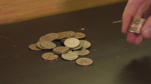 Softly placing a stack of Quarters on the table near the pile.