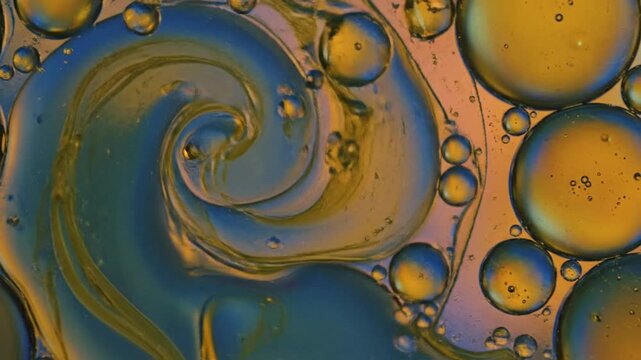 Macro Abstract Golden And Blue Oil Bubbles Swirling And Merging In Water Liquid Motion