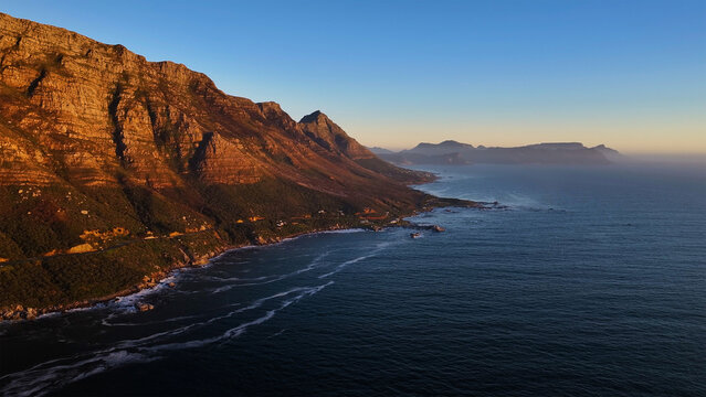 Aerial view of the rugged Twelve Apostles mountain range and the Atlantic coastline during golden hour Cape Town, Western Cape, South Africa.