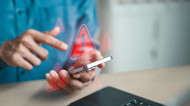 User holding smartphone with red warning alert icons, representing cyber threat detection, mobile security risks, privacy breaches and digital protection against online attacks.