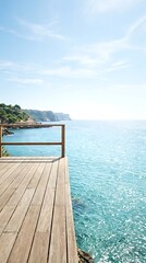 Obraz premium Wooden deck overlooking a tranquil turquoise sea and rugged coastline under a clear blue sky on a sunny day