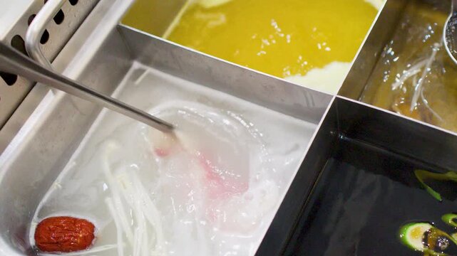 Thinly Sliced Beef Cooking in Boiling Broth at Hot Pot Restaurant