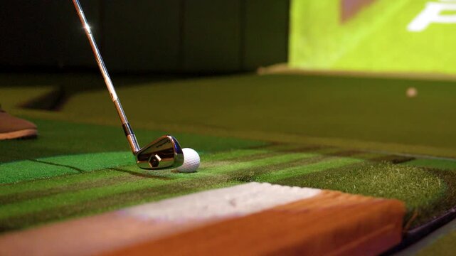 Close Up of Golf Club Hitting Ball in Indoor Simulator