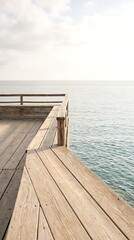 Fototapeta premium Wooden pier extending over calm blue ocean waters under a bright sky creating a serene coastal viewpoint for travel and relaxation