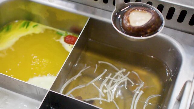 Ladle Scooping Shiitake Mushroom and Enoki From Boiling Hot Pot Soup