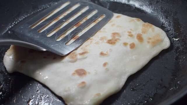 Making flatbread on a stovetop in the kitchen