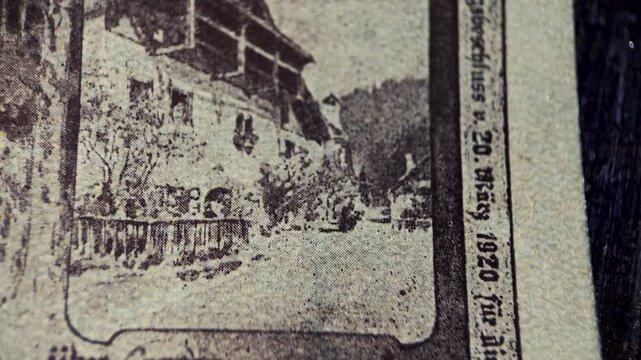 Close up video showing the reverse detail of an antique Goisern 20 heller notgeld banknote, highlighting monochrome village imagery, printed denomination, and aged paper texture.