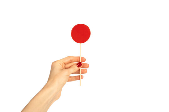 Round lollipop in female hand isolated on white background. Red manicure. Chupa Chups.