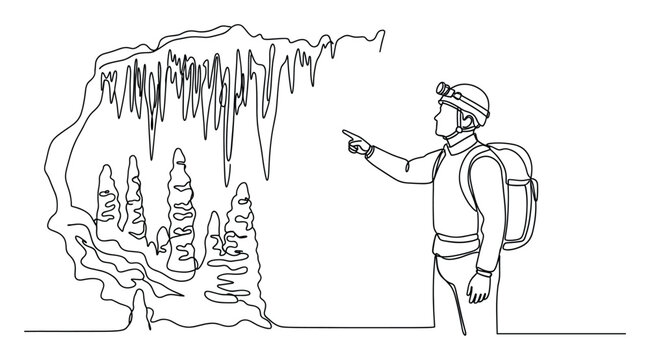 Adventurous speleologist points to natural stalactite and stalagmite cave formations for travel discovery concepts