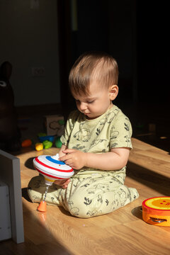 Toddler playing with toys on sunlit floor at home