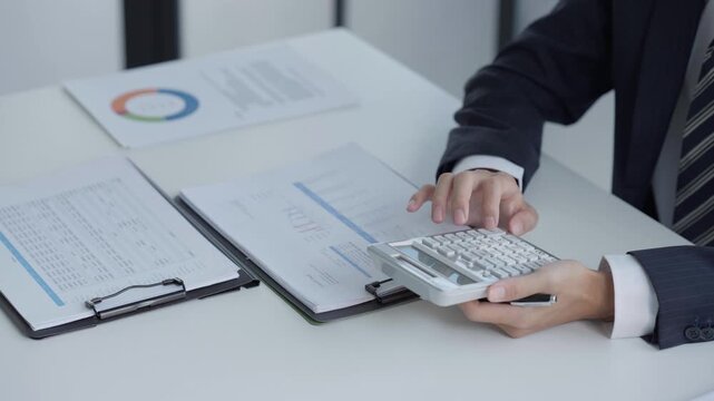 Asian businessman using calculator calculate fund for investment