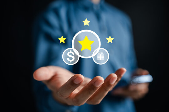 Loyalty points and customer rewards program solution. Man holding digital icons with star, dollar, and gift box for marketing.