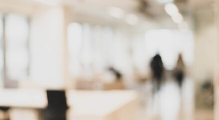 Fototapeta premium A blurred interior view of an office space featuring modern design elements, with people moving in the background, creating a dynamic, bustling atmosphere.
