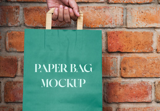Hand Holding Green Paper Bag Mockup PSD