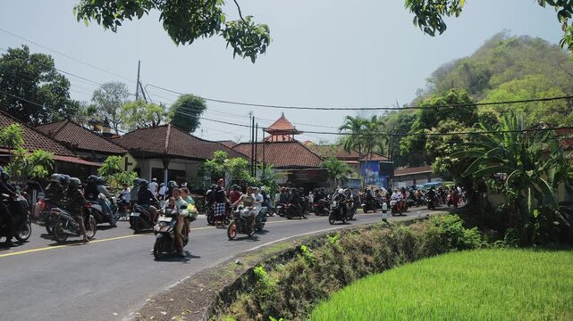 January 13, 2025 - Bali, Indonesia. Heavy scooter traffic on a busy street during rush hour.