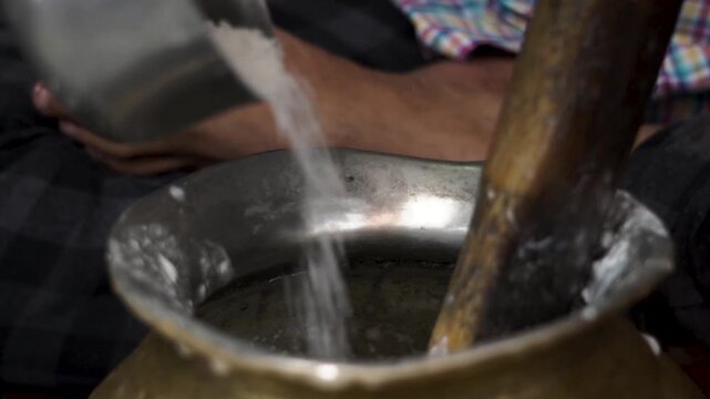 Extreme close up shot of making lassi from curd in vessel. Indian food preparation and dairy mixing process.