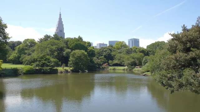 Kami-no-ike Pond At Shinjuku Gyoen National Garden In Tokyo, Japan, With Docomo Tower In Background. wide shot