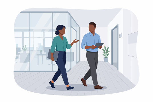 Colleagues walking and talking in modern office hallway