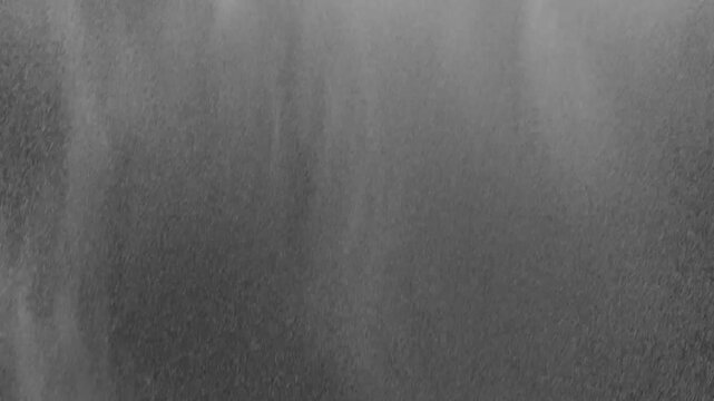 overlay of windblown rain on black background