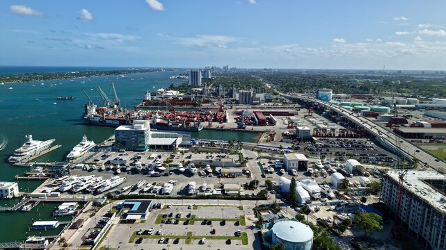 Aerial view of Riviera Beach Marina Village with luxury yachts, the Port of Palm Beach cargo terminal, and the Blue Heron Boulevard bridge in Riviera Beach, Florida, United States.