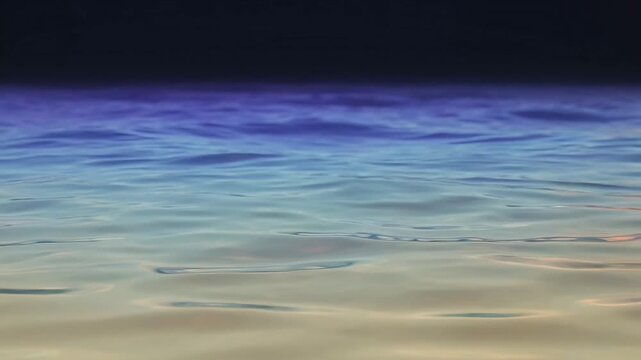 Gentle waves lapping on a sandy shore under a gradient sky