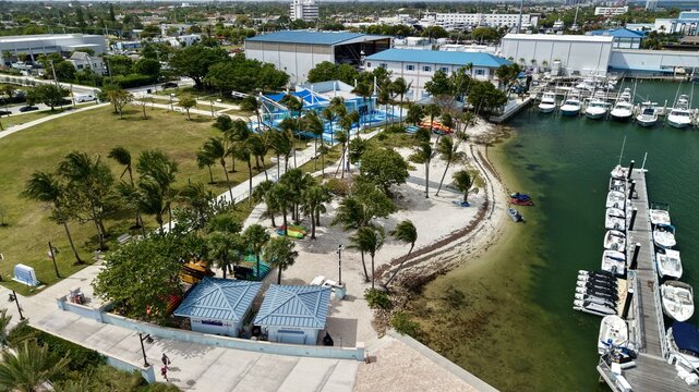 Aerial view of Peanut Island park featuring palm trees, blue-roofed buildings, and a marina filled with white boats in Palm Beach County, Florida, United States.