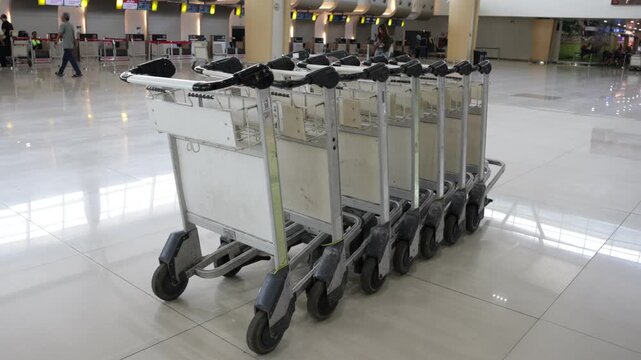 Empty carts stand in polished airport hall. Shiny floors reflect overhead lights softly. No travelers walk near the carts today. They await passengers who will need them. The scene looks quiet, calm
