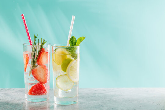 Two fresh non alcoholic drinks with strawberry and lemon on blue background