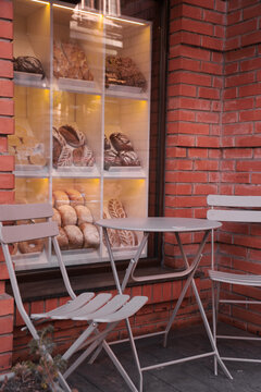 Bakery storefront with outdoor seating and a display of fresh bread